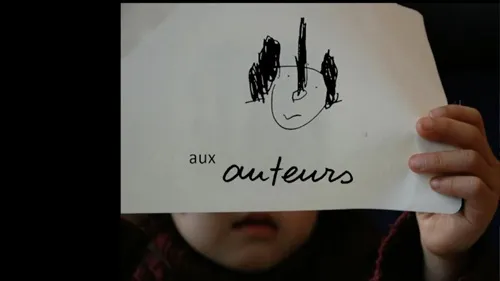 Une enfant qui tient une affiche ou est écrit "aux auteurs"