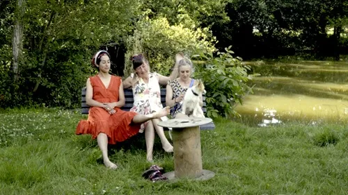 Trois femmes assises près d'un étang