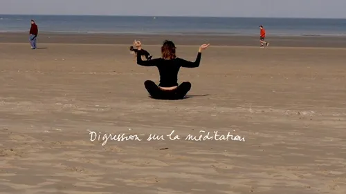 Une femme assise sur le sable