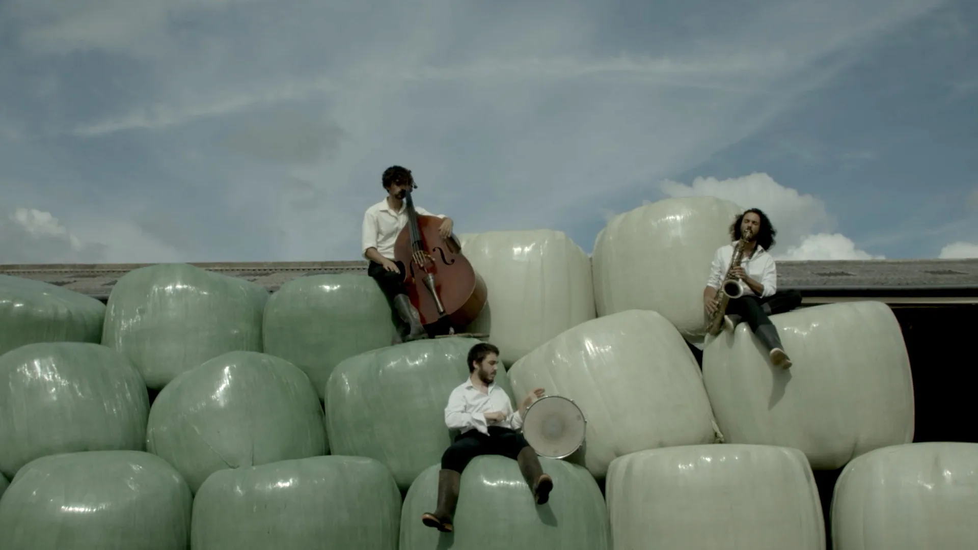 Des musiciens assis sur des bottes de paille