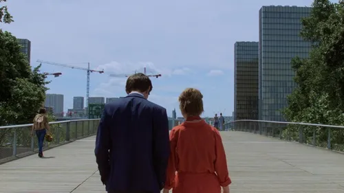 Deux personnes qui se promènent sur un pont, dans une grande ville